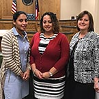 Three women standing together in a courthouse