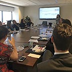 Photo of people in a boardroom watching a presentation