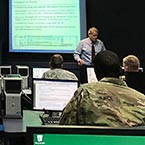 Photo of a presentation given by a Nelson Mullins attorney to a class of men wearing military jackets