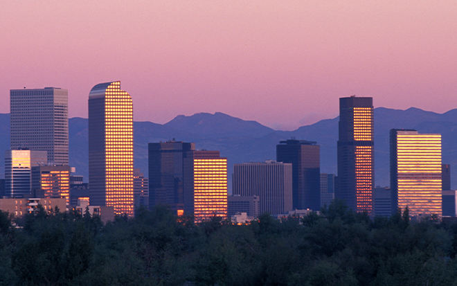 A cityscape with a sunset is pictured.