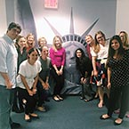 Photo of Nelson Mullins Employees in front of a Statue of Liberty poster
